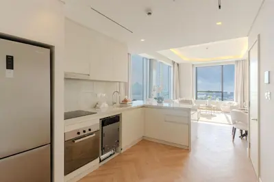 a kitchen with white appliances and a dining room at Daniels 1BR with Sea View at The Palm Tower in Dubai
