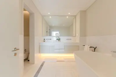 a white bathroom with a tub and a sink at Daniels 1BR with Sea View at The Palm Tower in Dubai