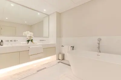 a white bathroom with a tub and two sinks at Daniels 1BR with Sea View at The Palm Tower in Dubai