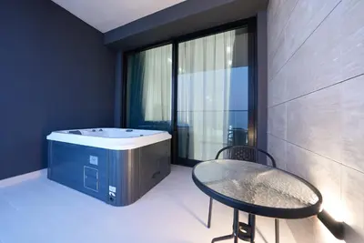 a bathroom with a tub and a table and a chair at Luxury Trillionaire Studio with Jacuzzi and Canal Views in Business Bay in Dubai