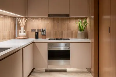 a kitchen with a stainless steel stove and cabinets at Seraya Residences at Address Opera Dubai in Dubai