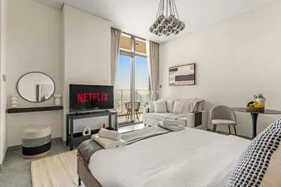 a bedroom with a king sized bed and a living room at VayK - Elegant Canal View studio in Business Bay in Dubai