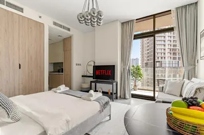 a bedroom with a large bed and a tv at VayK - Elegant Canal View studio in Business Bay in Dubai