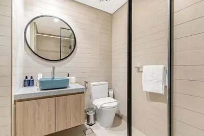 a bathroom with a toilet and a sink and a mirror at VayK - Elegant Canal View studio in Business Bay in Dubai