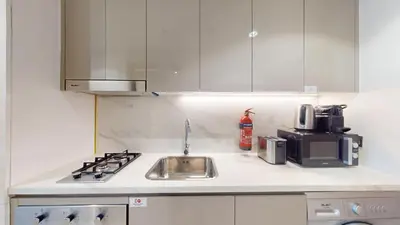 a kitchen counter with a sink and a stove at Locations l Luxurious Studio l Free Pool, Gym Access l Meydan in Dubai