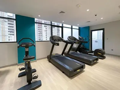 a gym with three exercise bikes in a room at Locations l Luxurious Studio l Free Pool, Gym Access l Meydan in Dubai