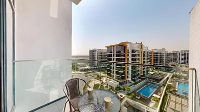 a balcony with a table and chairs and a view of a city at Locations l Luxurious Studio l Free Pool, Gym Access l Meydan in Dubai
