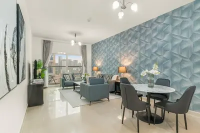 a living room with a table and chairs at Charming 1BR with Balcony and City View in JVC in Dubai