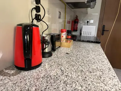 a red and black appliance sitting on a kitchen counter at Livincci - Luxury Studio Burj Khalifa View - 12 in Dubai