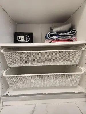 an open closet with white shelves and a radio at Livincci - Luxury Studio Burj Khalifa View - 12 in Dubai