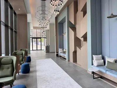 a lobby with a waiting room with chairs and a chandelier at Elegant Studio in Peninsula One, Business Bay in Dubai