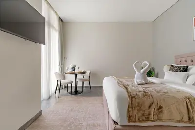 a bedroom with a bed and a table with chairs at Elegant Studio in Peninsula One, Business Bay in Dubai