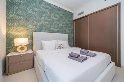 a bedroom with a bed with two towels on it at Beach access 2BR with Balcony & Sea View in Dubai
