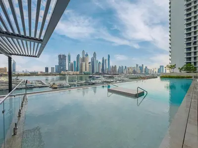 a swimming pool with a city skyline in the background at Beach access 2BR with Balcony & Sea View in Dubai
