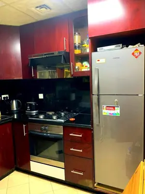 a kitchen with red cabinets and a stainless steel refrigerator at Come experience Dubai Marina with luxury capsule in Dubai