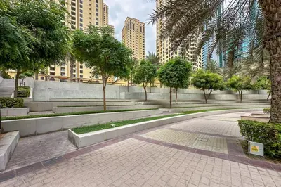a park with trees and benches in a city at Modern 1-Bedroom Apartment in Bay Central Tower 1 in Dubai