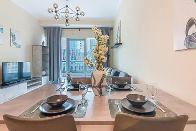 a dining room with a table with chairs and a television at Modern 1-Bedroom Apartment in Bay Central Tower 1 in Dubai