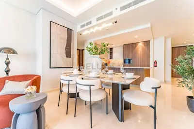a dining room and kitchen with a table and chairs at Breathtaking Burj Khalifa Views from a High-Floor 3BR with an Assistant Room, Just Minutes from Dubai Mall and Downtown Attractions, Imperial Avenue, Downtown Dubai by Deluxe Holiday Homes in Dubai