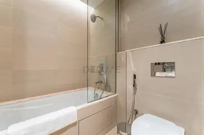 a bathroom with a tub and a toilet and a shower at Breathtaking Burj Khalifa Views from a High-Floor 3BR with an Assistant Room, Just Minutes from Dubai Mall and Downtown Attractions, Imperial Avenue, Downtown Dubai by Deluxe Holiday Homes in Dubai