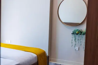 a bedroom with a mirror and a bed with a yellow blanket at 1Bedroom Canal View near Dubai Mall-Business Bay in Dubai
