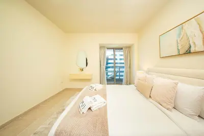 a white room with a bed and a mirror at PVH - Sea View 3BR and Maids Room - Princess Tower in Dubai