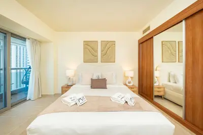 a bedroom with a large bed with two towels on it at PVH - Sea View 3BR and Maids Room - Princess Tower in Dubai