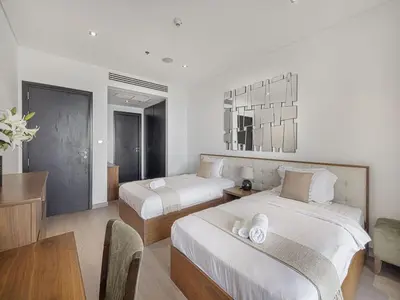 a hotel room with two beds and a table at Livin' Holidays - 2 BR - Anantara Palm Stay in Dubai