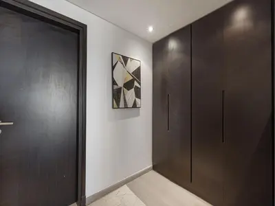a hallway with wooden doors and a painting on the wall at Livin' Holidays - 2 BR - Anantara Palm Stay in Dubai