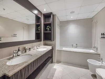 a bathroom with two sinks and a large mirror at Livin' Holidays - 2 BR - Anantara Palm Stay in Dubai