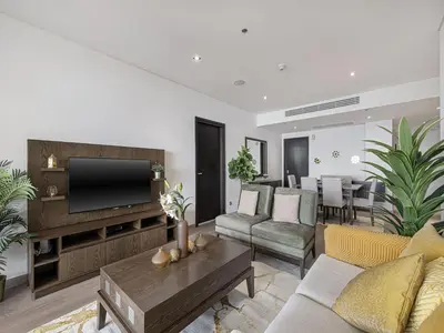 a living room with a couch and a tv at Livin' Holidays - 2 BR - Anantara Palm Stay in Dubai