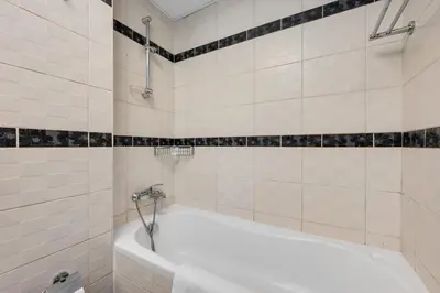 a white tub in a bathroom with black and white tiles at Modern 1BR I Canal View I Business Bay Dubai in Dubai