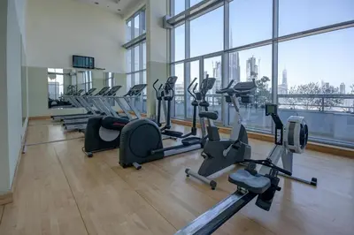 a gym with a row of treadmills and exercise machines at Modern 1BR I Canal View I Business Bay Dubai in Dubai