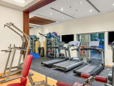 a gym with several treadmills and machines in a room at FIRST CLASS 1BR Burj Khalifa View , Near Metro in Dubai