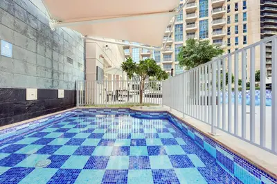 a swimming pool with a tile floor in a building at FIRST CLASS 1BR Burj Khalifa View , Near Metro in Dubai