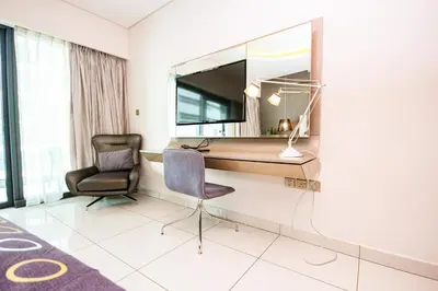 a room with a desk and a chair and a mirror at Modern 1BHK With World Class Amenities at Paramount Tower in Dubai