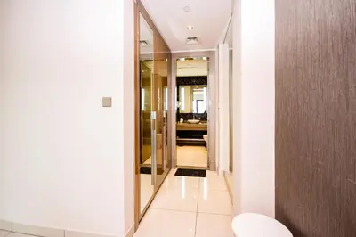 a hallway leading to a bathroom with a mirror at Modern 1BHK With World Class Amenities at Paramount Tower in Dubai