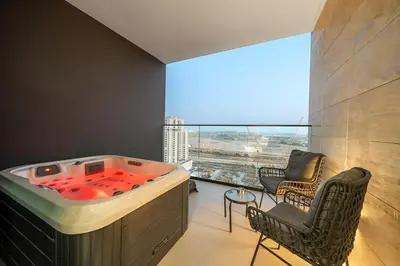 a large tub in a room with a large window at FIRST CLASS Studio Canal and Pool View in Dubai