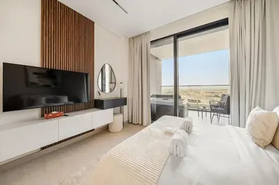 a white bedroom with a tv and a bed with at FIRST CLASS Studio Canal and Pool View in Dubai