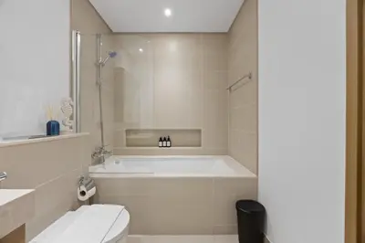 a bathroom with a bath tub and a toilet at Luxury Seaview Apartment Near Bluewaters & JBR in Dubai