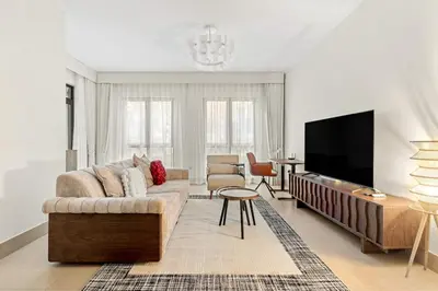 a living room with a couch and a flat screen tv at FIRST CLASS 1BR Cozy Old Town Escape in Dubai