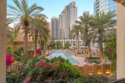 a view of a resort with a pool and palm trees at FIRST CLASS 1BR Cozy Old Town Escape in Dubai