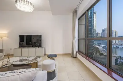 a living room with a large window and a tv at Rimal 1 JBR Beach Access 3 BR in Dubai