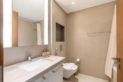 a bathroom with a sink and a toilet and a mirror at PVH - Vibrant 1BR near Dubai Opera - BLVD Heights in Dubai
