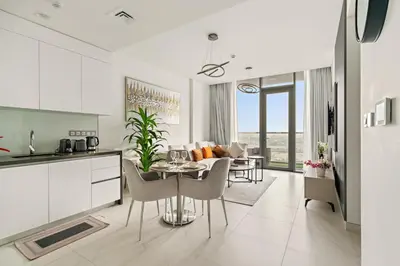a kitchen and living room with a table and chairs at FIRST CLASS 1BR Cozy Luxe Escape in Dubai