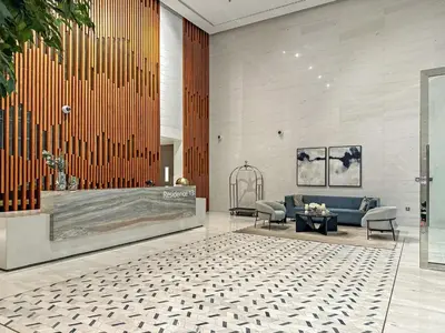 a lobby with a blue couch and a table at FIRST CLASS 1BR Cozy Luxe Escape in Dubai