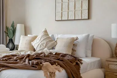 a bed with white pillows and a blanket on it at Serene 1BR Retreat with Pool & Gym by Safa Park in Dubai