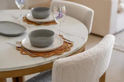 a table with plates and wine glasses on it at Serene 1BR Retreat with Pool & Gym by Safa Park in Dubai