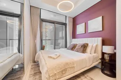 a bedroom with a white bed and a purple wall at FAM Living - 2 Bedroom Aykon City Dubai in Dubai