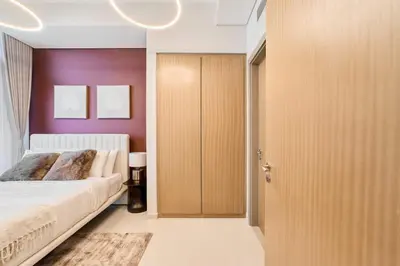 a bedroom with a bed and a purple wall at FAM Living - 2 Bedroom Aykon City Dubai in Dubai