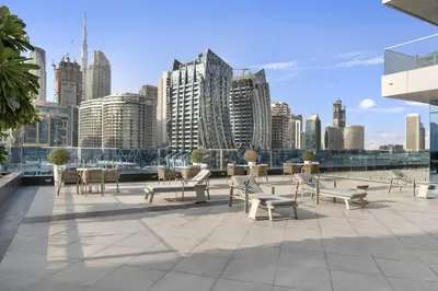 a patio with chairs and tables and a city skyline at Stylish 1BR Canal View & 12 min to Downtown in Dubai